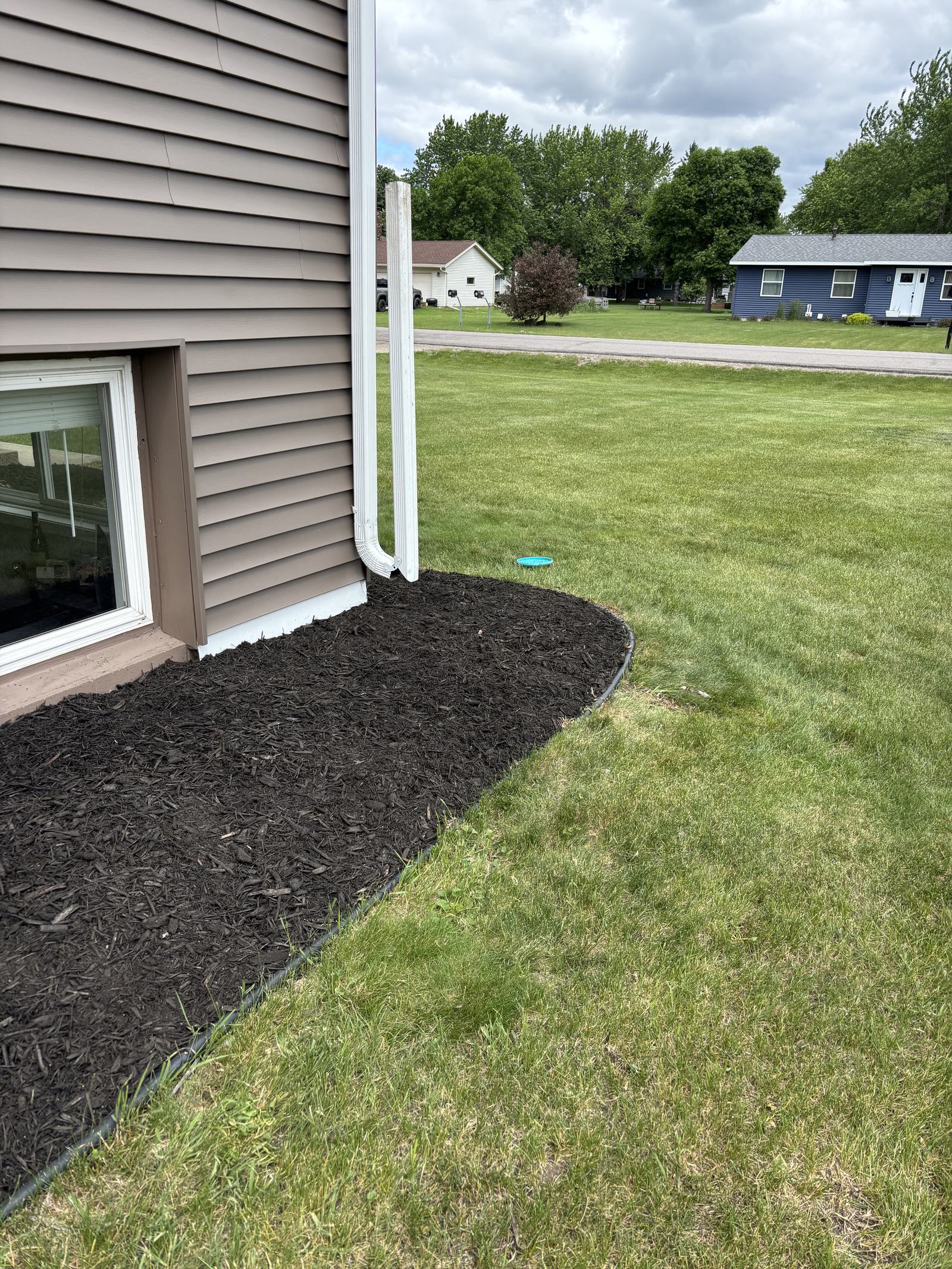 Curved mulch bed along a house